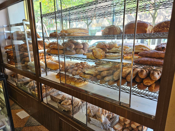 Display case with various types of bread in a bakery setting