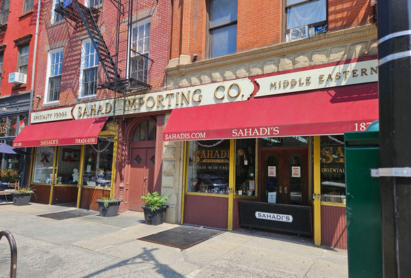 Sahadi Importing Co. building with red awning and storefront entrance.