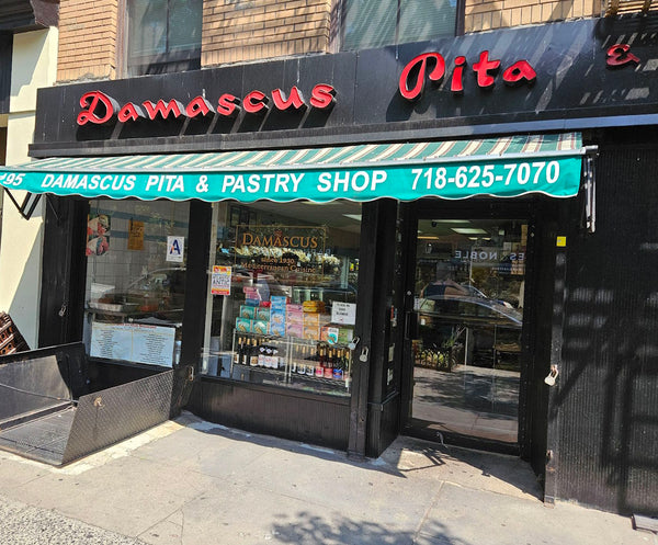  storefront of Damascus Pita & Pastry Shop with green and black facade